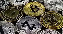 A lot of cryptocurrency coins lie on a dark surface